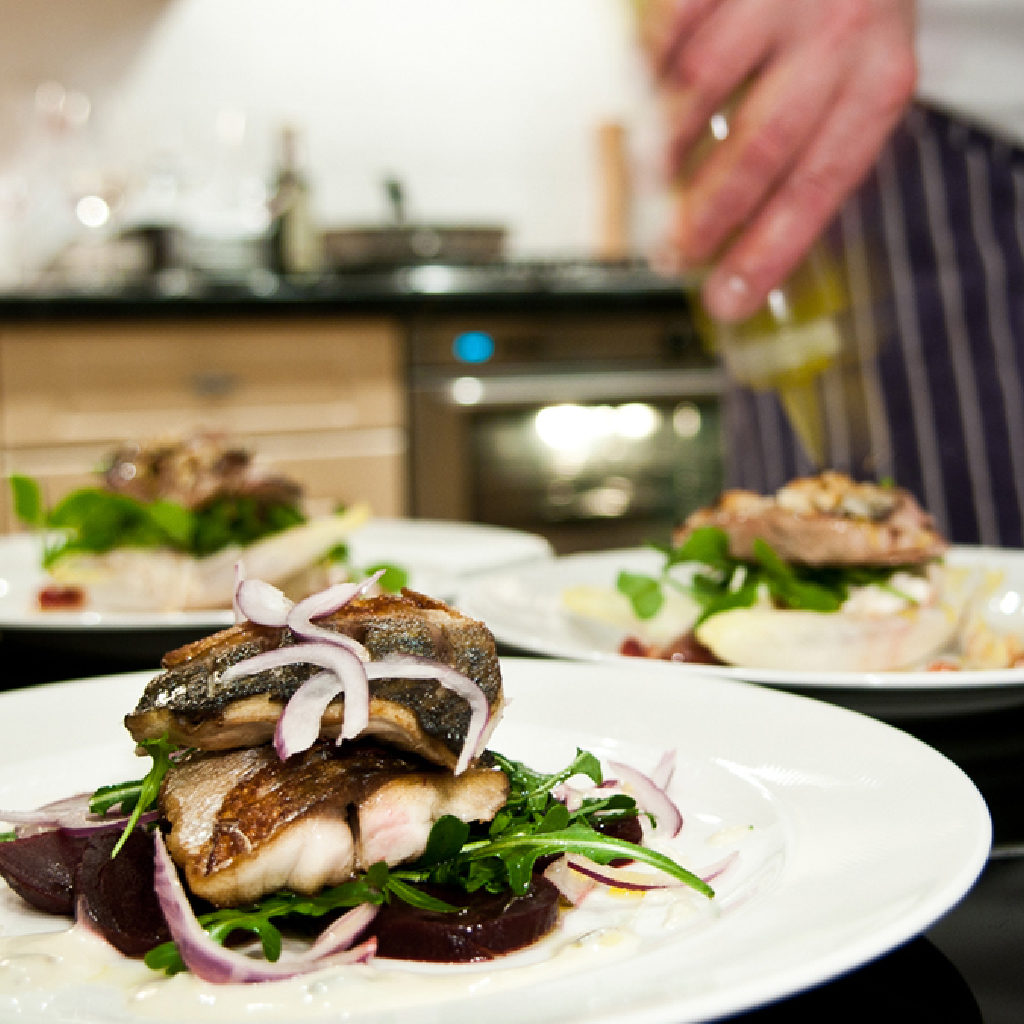 Chef Plating Sea-bass with Micro Greens and Vegetables