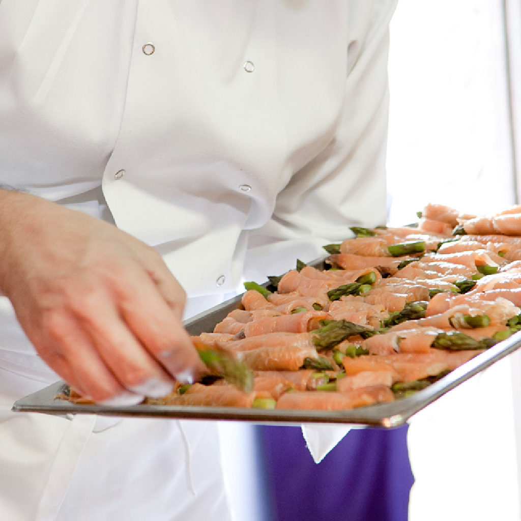 Chef with a Tray of Salmon and Asparagus Rolls