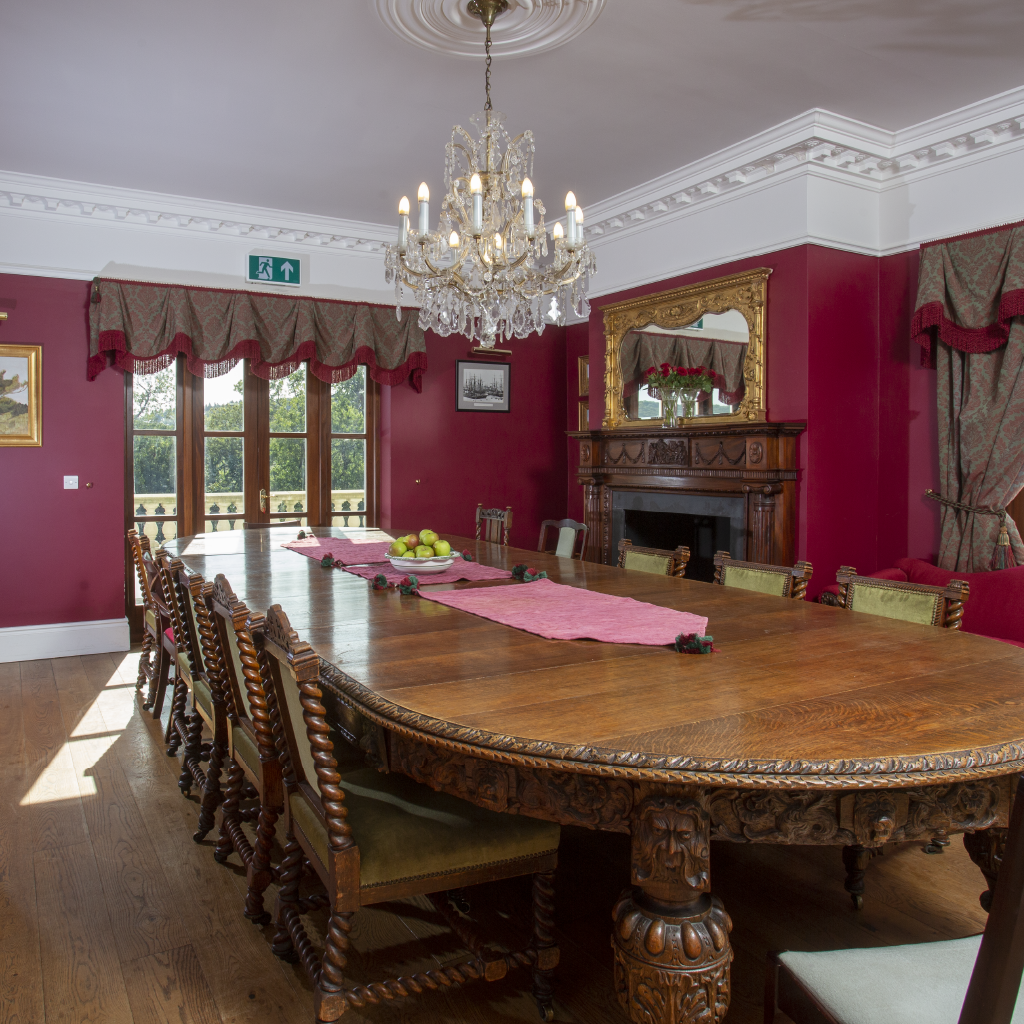Dining Room with Large Wooden Carved Table and Dark Red Walls
