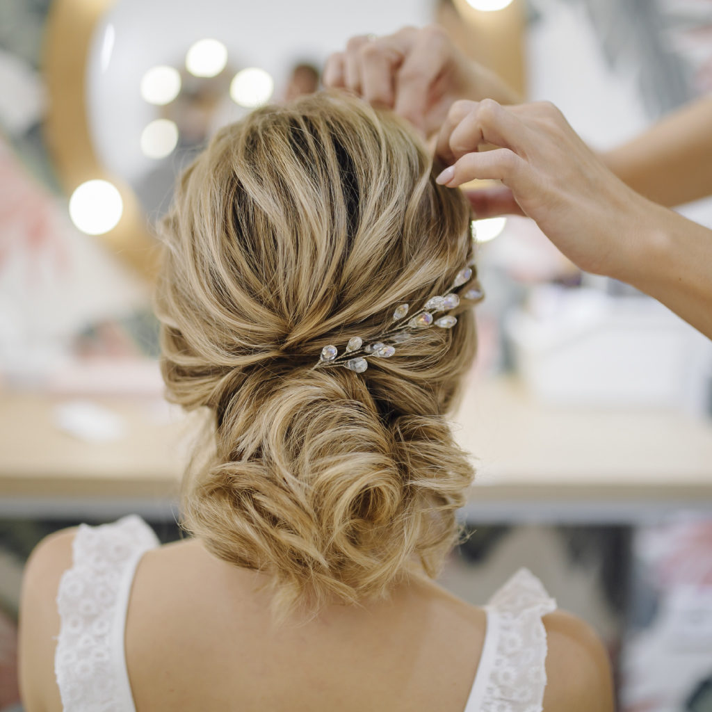 Hairdresser Weaving and Braiding Hair of Bride