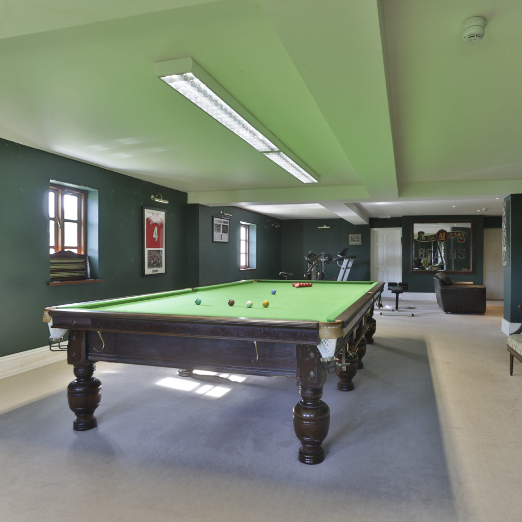 Pool Table in Large Room with Teal Walls